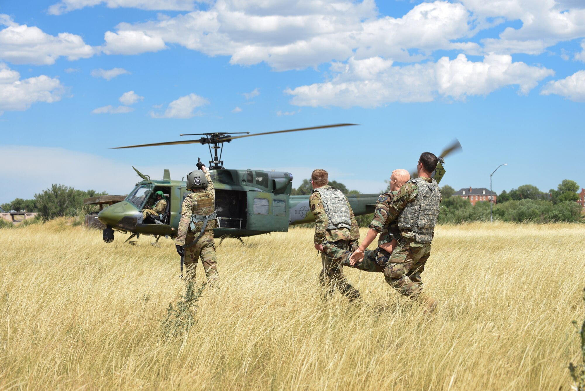 90th Mission Support Group Airmen carry an injured dummy for emergency helicopter evacuation in a tactical convoy exercise during Warrior Day at F.E. Warren Air Force Base, Wyoming, Aug. 15, 2019. The training allowed Airmen an opportunity to experience simulated convoy operations in a controlled environment. (U.S. Air Force photo by Senior Airman Abbigayle Williams)