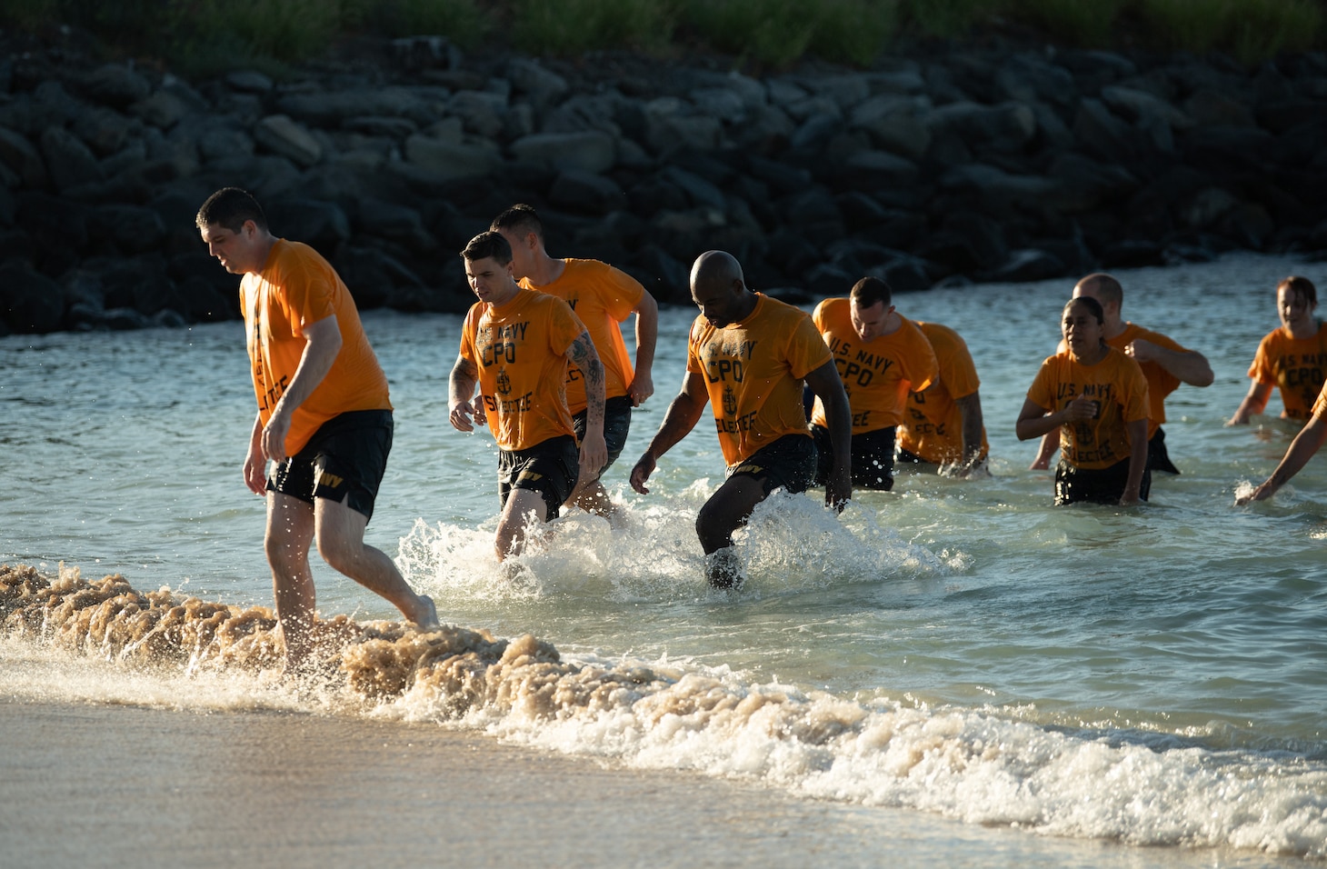 A group of chief selectees coming out of the surf.