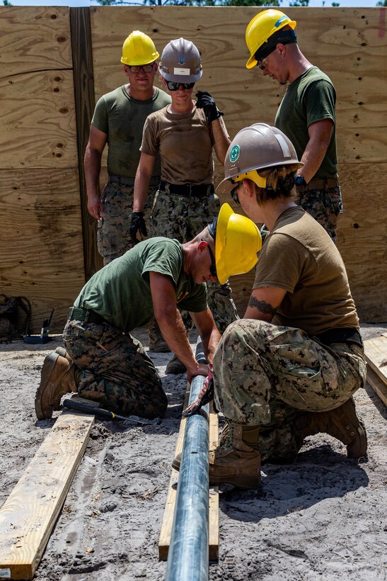 U.S. Marine with 2nd Combat Engineer Battalion, 2nd Marine Division, as well as sailors with Naval Mobile Construction Battalion One, drill into a pipe during a leadership course and bunker construction on Camp Lejeune, N.C., Aug. 13, 2019. The joint construction training between the Navy and the Marine Corps was conducted for the first time in fifteen years, strengthening joint military standards, relationships, and camaraderie. (U.S. Marine Corps photo by Lance Cpl. Kensie S. Milner)