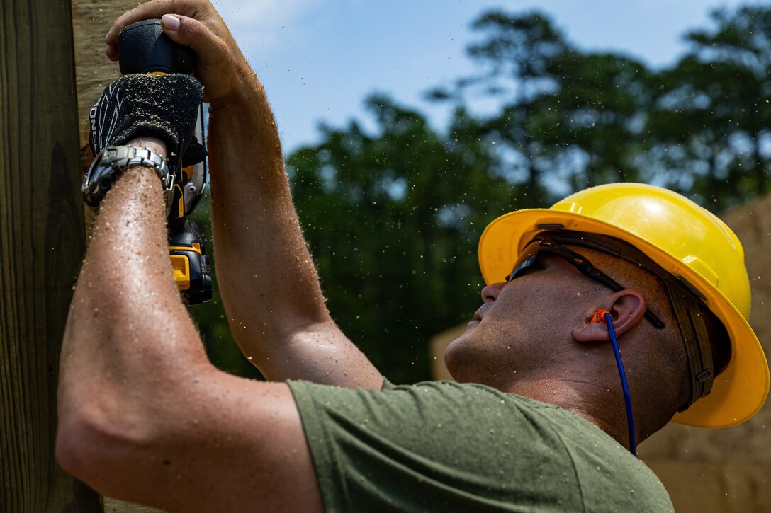 U.S. Marine Gunnery Sgt. Steven T. Pfeffer, combat engineer with 2nd Combat Engineer Battalion, 2nd Marine Division, sands down a door frame during a leadership course and bunker construction on Camp Lejeune, N.C., Aug. 13, 2019. The joint construction training between the Navy and the Marine Corps was conducted for the first time in fifteen years, strengthening joint military standards, relationships, and camaraderie. (U.S. Marine Corps photo by Lance Cpl. Kensie S. Milner)