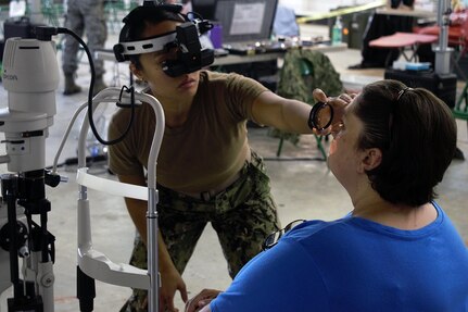 U.S. Navy Reserve Lt. Gillian Claveria-Oooms, optometrist, Expeditionary Medical Facility Dallas One, Ft. Worth, Texas, examines a patient at Innovative Readiness Training Appalachian Care 2019 at Wise County Fairgrounds, Wise, Va., Aug. 18, 2019.