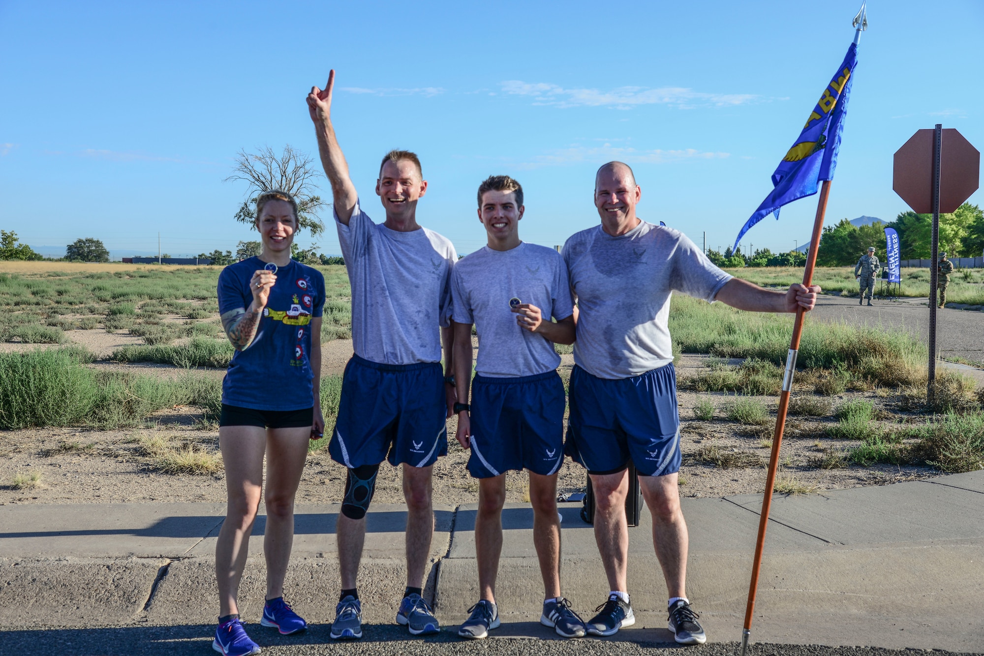 U.S. Air Force Col. David S. Miller, 377th Air Base Wing commander (second from the left), and Chief Master Sgt. Robert Stamper, 377th ABW command chief (right), pose with the 1st place female and male winners of the Wing Tiger Run at Kirtland Air Force Base, N.M., August 16, 2019. Annie Pennington and Air Force ROTC Cadet Brendan Kapp received coins for their performance during the quarterly Wing Tiger Run. (U.S. Air Force Photo by Airman 1st Class Kiana Pearson)