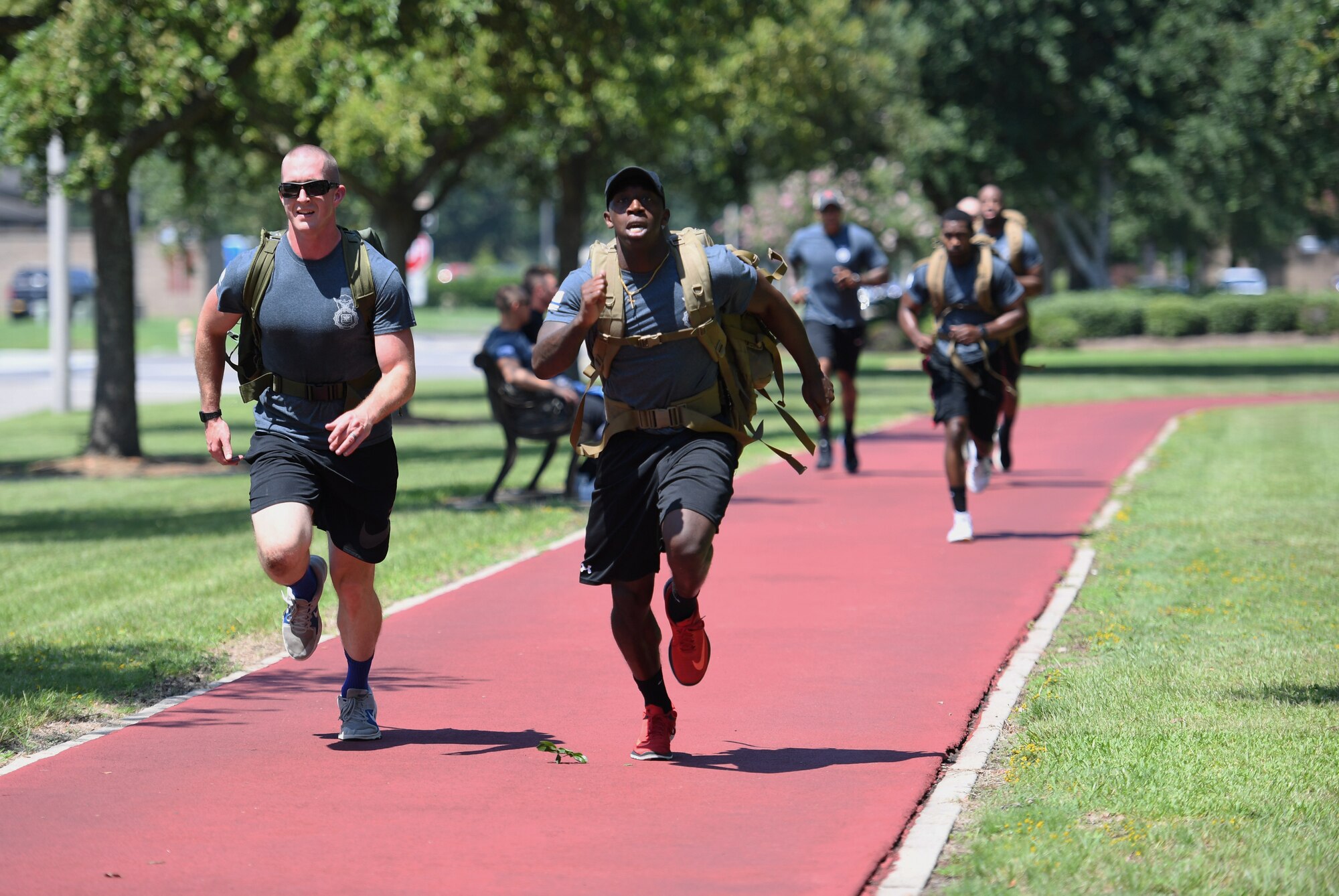 U.S. Air Force Staff Sgt. Jesse Daniel, 81st Security Forces Squadron confinement NCO in charge, and Staff Sgt. Tradarius Christian, 81st SFS police services, lead their team in running a lap while carrying ruck sacks during the 81st SFS Defender's Challenge Ruck on the Crotwell Track on Keesler Air Force Base, Mississippi, Aug. 16, 2019. The competition, consisting of 11 four-person teams, completing seven obstacles, was one of several events in recognition of The Year of the Defender. (U.S. Air Force photo by Kemberly Groue)
