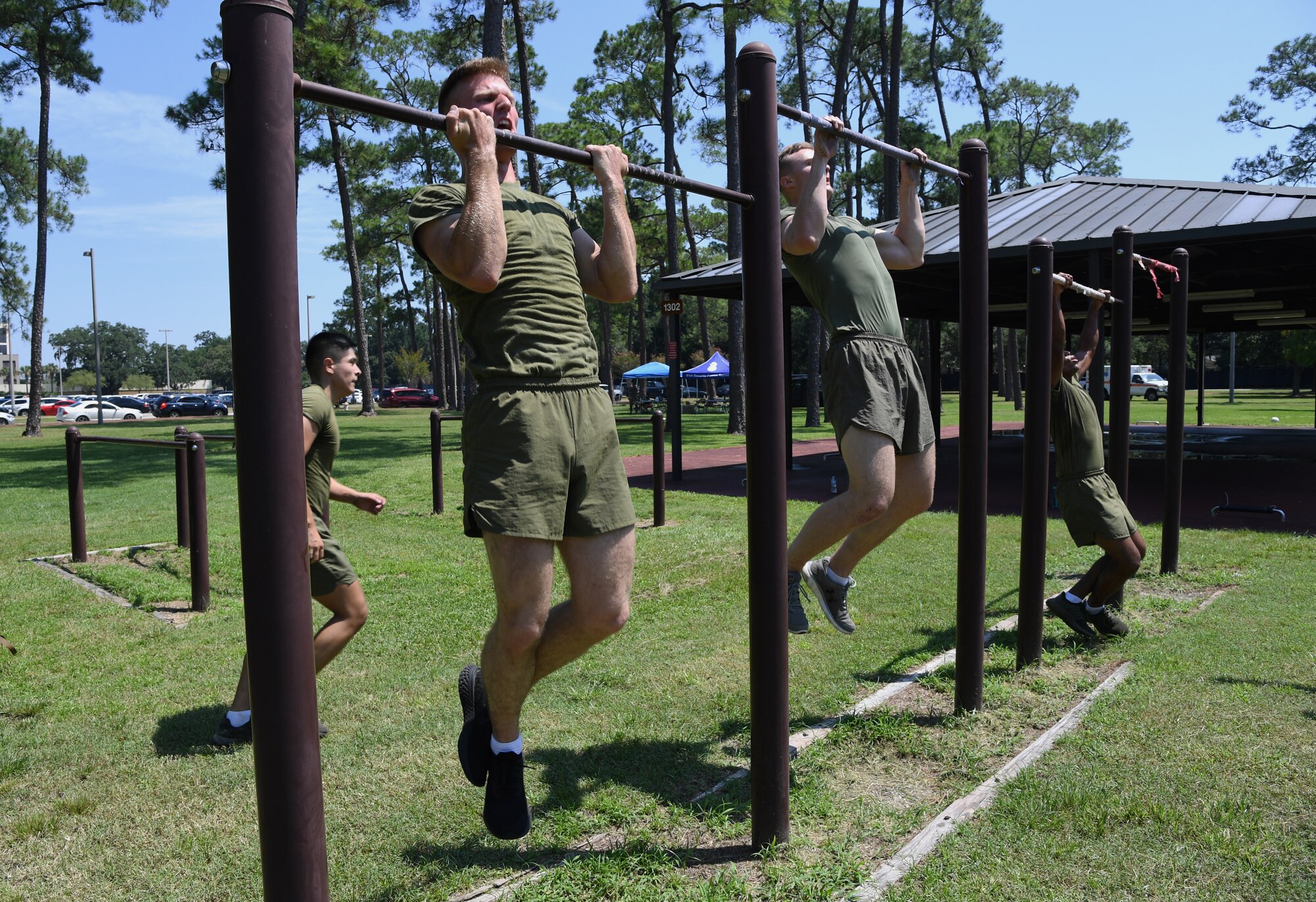 Members of the Keesler Marine Detachment team participate in the pull-up portion of the 81st Security Forces Squadron Defender's Challenge Ruck near the Crotwell Track on Keesler Air Force Base, Mississippi, Aug. 16, 2019. The competition, consisting of 11 four-person teams, completing seven obstacles, was one of several events in recognition of The Year of the Defender. (U.S. Air Force photo by Kemberly Groue)