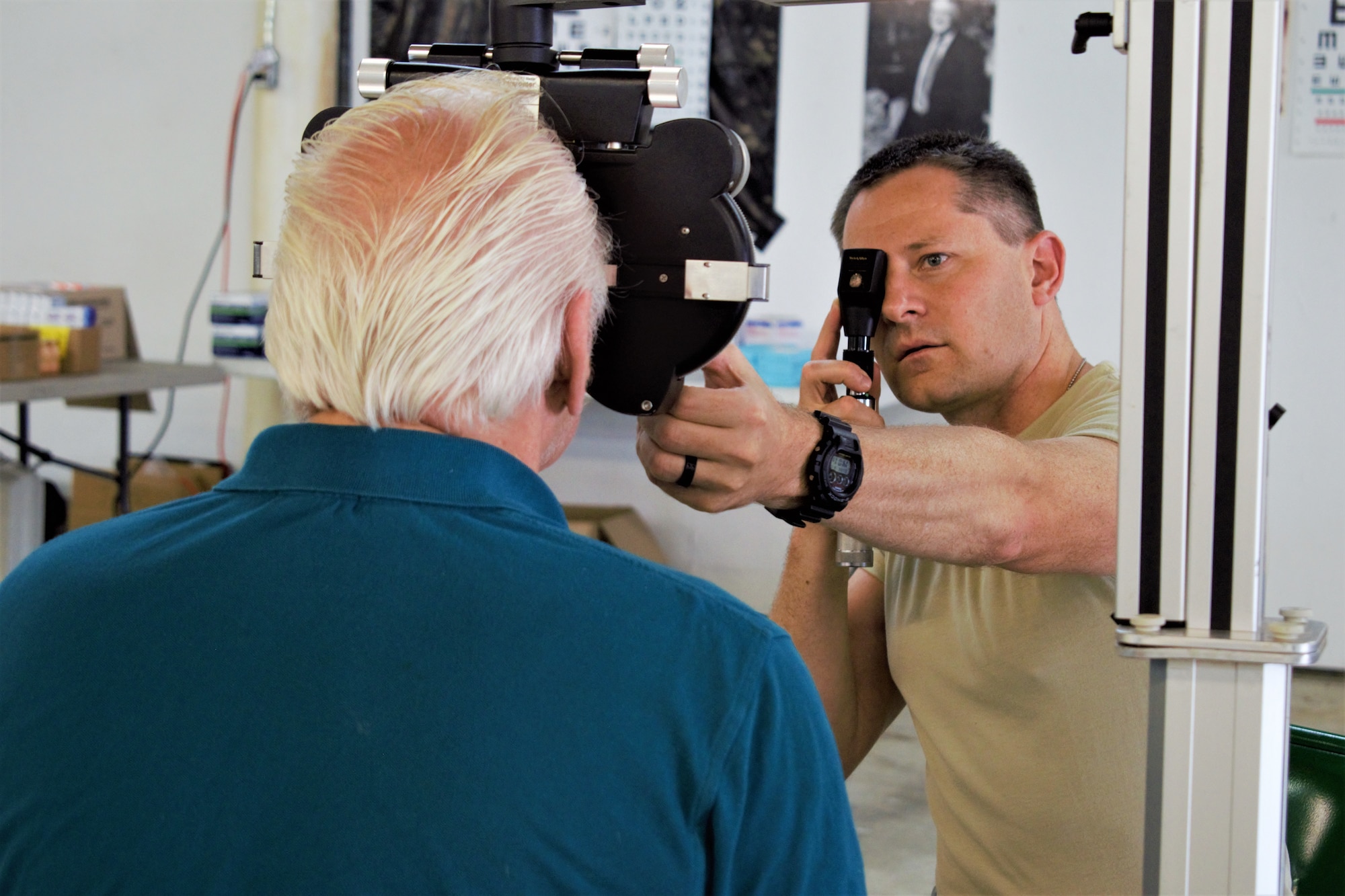 U.S. Air Force Maj. Joshua Metzger, optometrist, 127th Medical Group, Selfridge Air National Guard Base, Michigan, examines a patient during Appalachian Care Innovative Readiness Training 2019 at Wise County Fairgrounds, Wise, Virginia, Aug. 18, 2019. Appalachian Care IRT takes place Aug. 16-29 to provide medical, dental, optometry and veterinary care to assist local health and municipal authorities in addressing underserved and unmet community health and civic needs in Wise, Virginia, while simultaneously conducting deployment and readiness training for military personnel. Innovative Readiness Training is the only hands-on training opportunity authorized to operate within the United States. During Appalachian Care IRT, medical operations are staged at one physical location at Wise County Fairgrounds. Units also conduct critical mission training and logistical movement to simulate hands-on deployment readiness operations and health care delivery in times of crisis, conflict or disaster. (U.S. Air National Guard photo by 1st Lt. Andrew Layton)