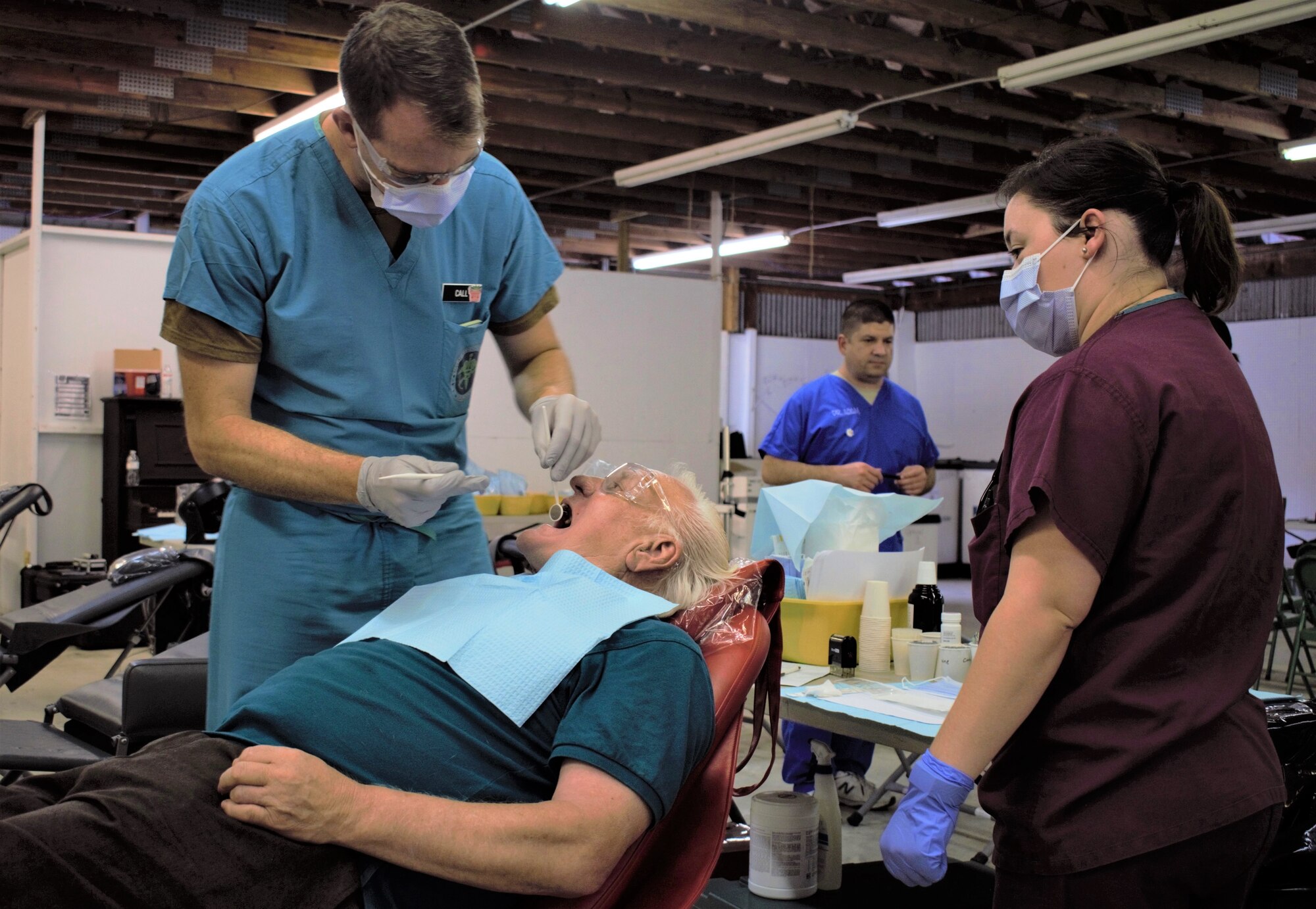 U.S. Navy Reserve Lt. Cdr. Derrick Call, dentist, Operational Heath Support Unit San Diego, Ca., examines a patient during Innovative Readiness Training Appalachian Care 2019 at Wise County Fairgrounds, Wise, Va., Aug. 18, 2019. Appalachian Care Innovative Readiness Training 2019 takes place Aug. 16-29, 2019, to care for the medically underserved communities of Wise, Virginia while simultaneously conducting deployment and readiness training for military personnel. Innovative Readiness Training is the only hands-on training opportunity authorized to operate within the U.S. During Appalachian Care IRT 2019, medical operations will be staged at one physical location at Wise County Fairgrounds. The Appalachian Care IRT 2019 team provides medical, dental, optometry and veterinary care to assist local health and municipal authorities in addressing underserved and unmet community health and civic needs. Units also conduct critical mission training and logistical movement in order to simulate hands-on deployment readiness operations and health care delivery in the time of crisis, conflict or disaster. (Air National Guard photo by 1st Lt. Andrew Layton)