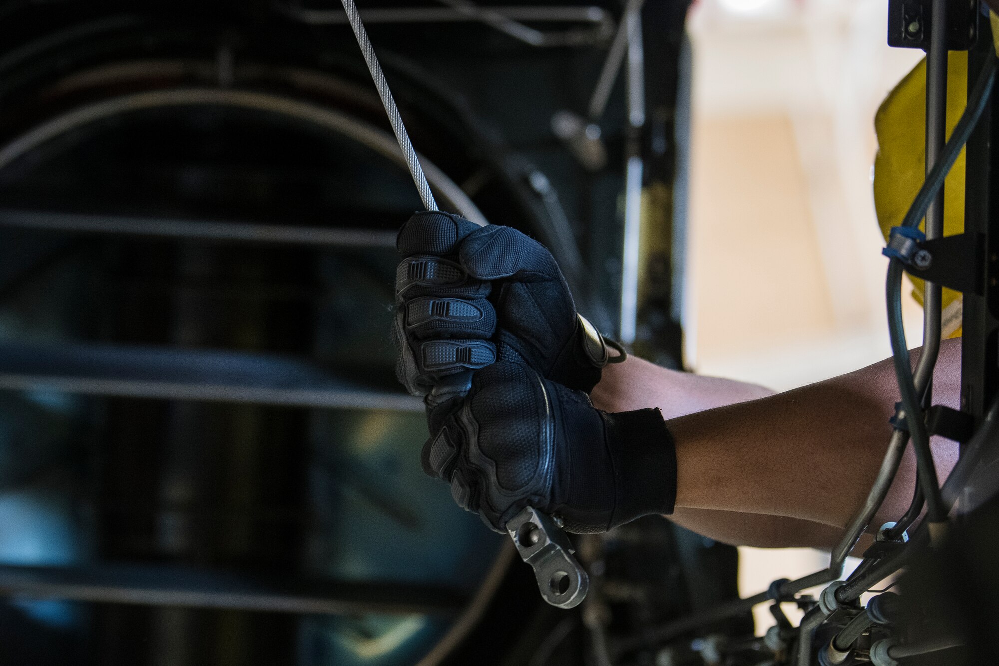 Airman 1st Class Omar Rodriguez Maisonet, 727th Special Operations Aircraft Maintenance Squadron crew chief, guides a cable to an engine below at Cannon Air Force Base, N.M, Aug. 13, 2019. The process of replacing the engine took the team of three 25 minutes. (U.S. Air Force Photo by Senior Airman Vernon R. Walter III)