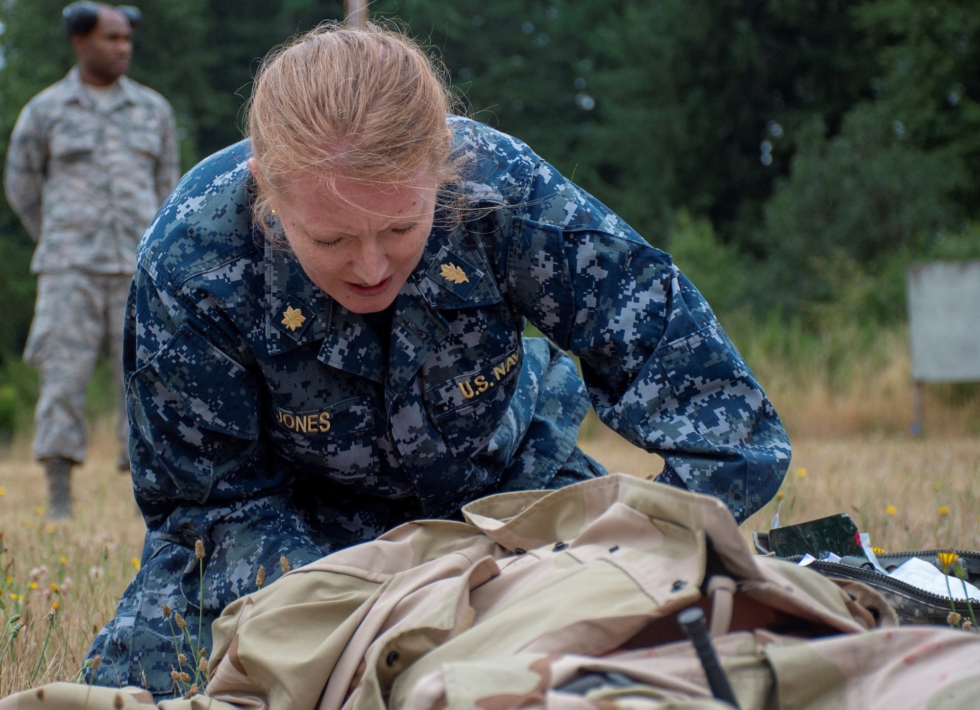 Lt. Cmdr. Katie Jones, assigned to Operational Hospital Support Unit Bremerton, tends to a simulated casualty during a tactical combat casualty care (TCCC) class for exercise Tropic Halo 2019 at Joint Base Lewis-McChord in Tacoma, Wash., Aug. 7, 2019. Tropic Halo is designed to enhance Operational Hospital Support Unit Bremerton's medical and mission capabilities on several levels: increase TCCC and trauma nurse core course readiness rates while minimizing overall training costs; promote intra-service cohesion with collaborative training in a joint service environment and leverage Navy and Air Force command assets to generate better training opportunities. (U.S. Navy photo by Mass Communication Specialist 1st Class Ryan Riley)