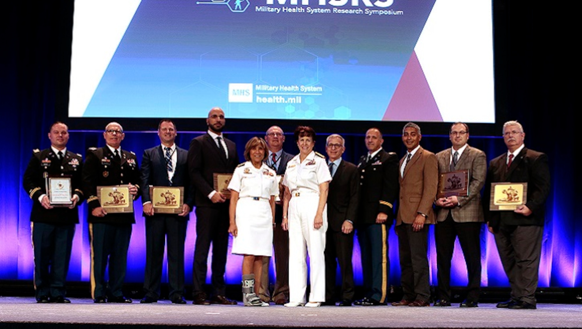 Navy Vice Adm. Raquel C. Bono and Navy Rear Adm. Mary C. Riggs join individual and team award winners honored at the 2019 Military Health System Research Symposium on Monday, August 19th in Kissimmee, Florida. (MHS photo)