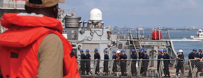 Sailors Man the Rails as Tugboats Guide USS Mitscher