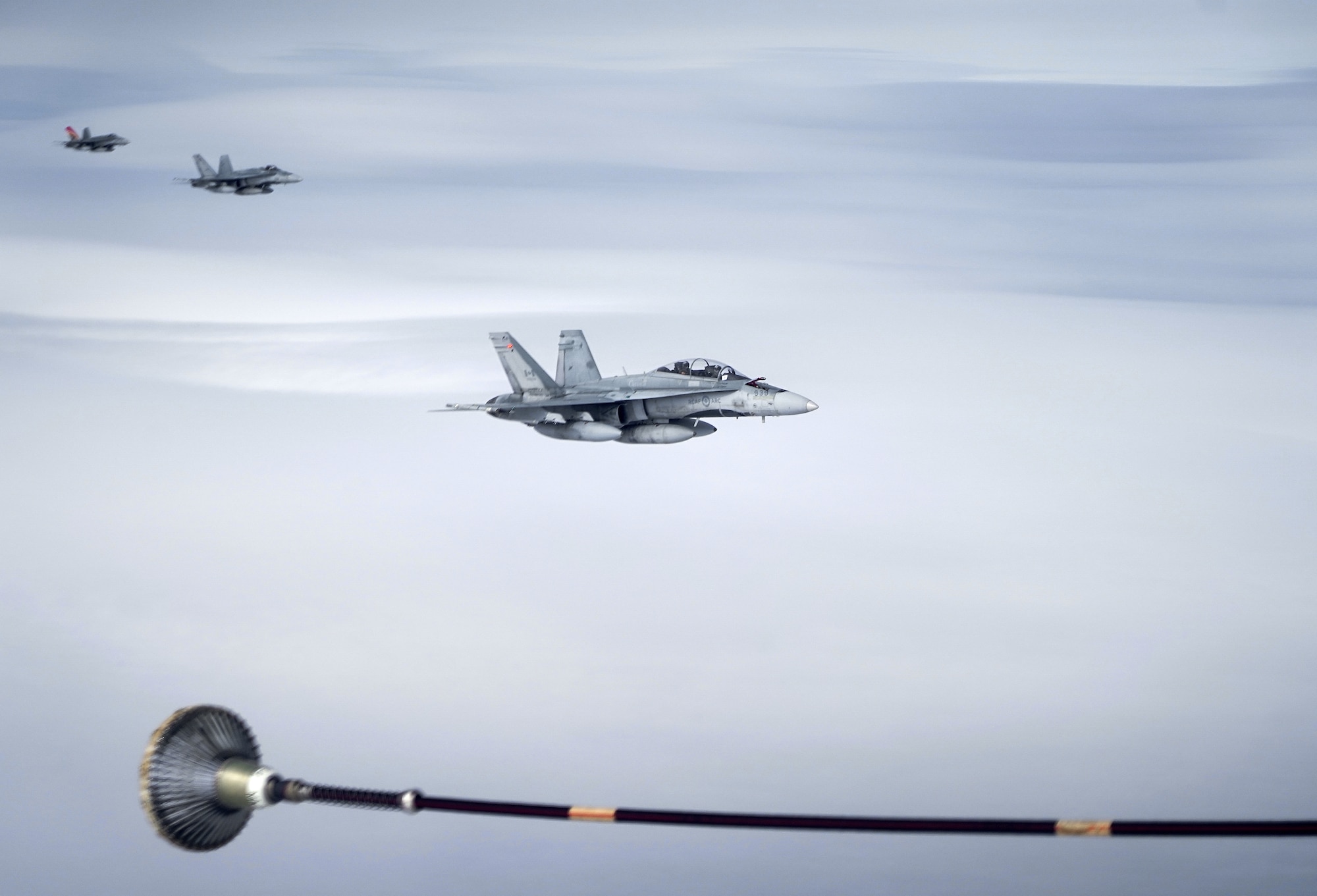Three Royal Canadian Air Force CF-18 Hornets pull up to a CC-150 Polaris refueling tanker as RCAF Airmen assigned to the 437th Transport Squadron based out of Canadian Forces Base Trenton, Canada, perform refueling operations in training airspace over Alaska during the Red Flag-Alaska 19-3 exercise, Aug. 15, 2019. Red Flag-Alaska, a series of Pacific Air Forces commander-directed field training exercises for U.S. forces, provides joint offensive counter-air, interdiction, close air support, and large force employment training in a simulated combat environment.