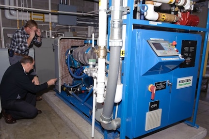 A.J. Ballard, the energy manager for the Maine Army National Guard points out some of the engine details of the award-winning combined heat and power system at the Maine Army National Guard Army Aviation Support Facility in Bangor, Maine. "This is a wonderful machine," said Ballard. "This system produces electricity we don't have to pay for, and heat we don't have to pay for."