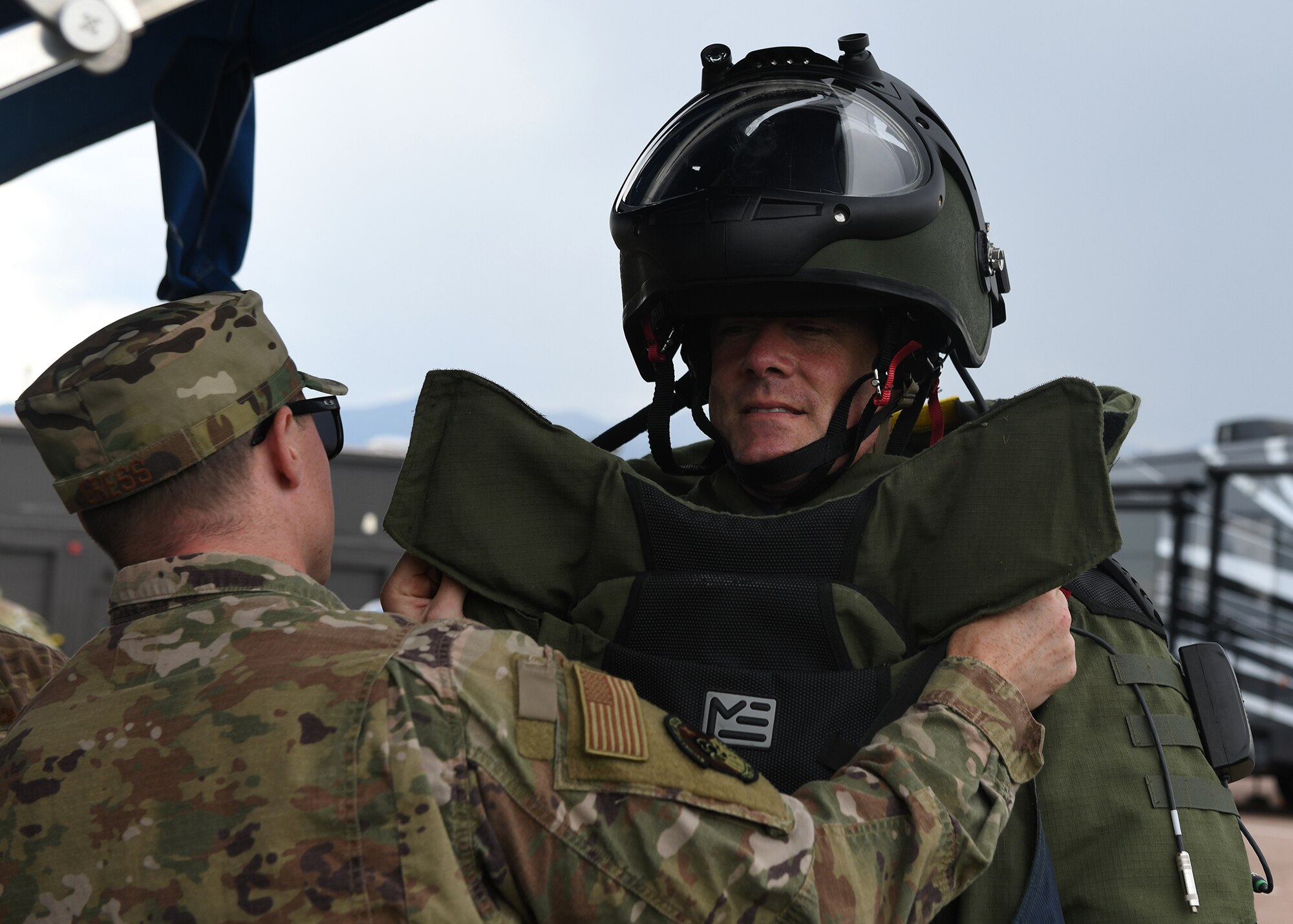 Staff Sgt. Lawrence Gress, 21st Civil Engineer Squadron explosive ordnance disposal technician, left, helps Col. Thomas Falzarano, 21st Space Wing commander, get into a bomb suit Aug. 7, 2019 on Peterson Air Force Base, Colorado. During a tour of the CES, Falzarano also met the EOD Airmen and participated in a bomb simulation. (U.S. Air Force photo by Airman 1st Class Andrew Bertain)