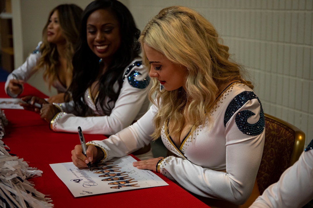 Los Angeles Rams cheerleader Michelle signs a poster during a meet and greet at Kahuna's Sports Bar & Grill Ballroom, Marine Corps Base Hawaii (MCBH), Aug. 12, 2019. Marine Corps Community Services invited the LA Rams cheerleaders to MCBH to give personnel on base the opportunity to take pictures and get autographs. (U.S. Marine Corps photo Cpl. Zachary Orr)