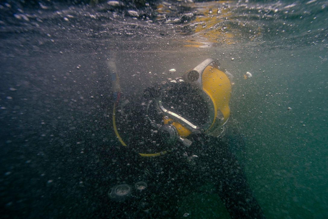 Army diver swimming underwater.