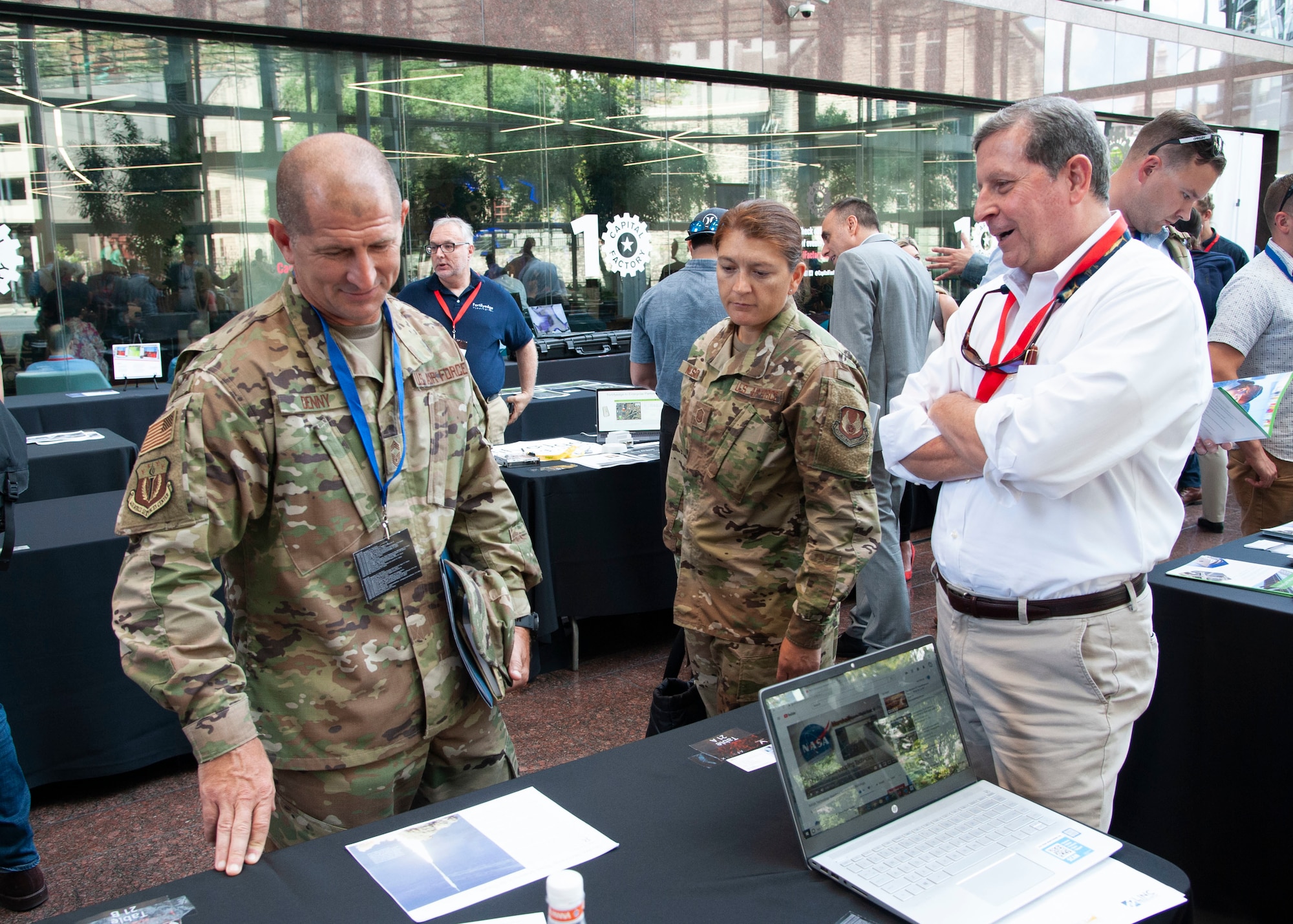 Two Airmen talk with a Phase I Small Business Innovation Research entrepreneur of the program during the first-ever Spark Collider at the AFWERX Austin Hub Aug 14, 2019. The event connected approximately 100 Phase I Small Business Innovation Research companies and Airmen from about 50 bases to potentially solve Air Force problem areas. (U.S. Air Force courtesy photo)
