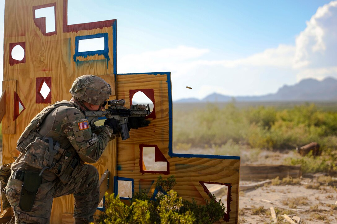 A soldier fires a weapon from behind a wooden wall.