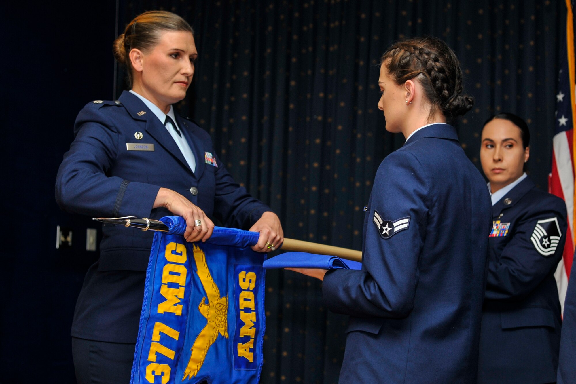 Lt. Col. Leigh Johnson, 377th Aerospace Medicine Squadron commander, furls the squadron guidon in a redesignation ceremony at Kirtland Air Force Base, N.M., August 16, 2019. The 377th Operational Medical Readiness Squadron will provide care for active duty service members while the 377th Healthcare Operations Squadron will provide care for non-active duty personnel. (U.S. Air Force photo by Airman 1st Class Austin J. Prisbrey)