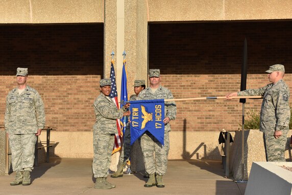 U.S. Air Force Lt. Col. Warren Conrow, 17th Healthcare Operations Squadron commander, and Col. Lauren Byrd, 17th Medical Group commander, unfurl the new guidon signifying the inactivation of the 17th Medical Support Squadron and the activation of the 17th HCOS during the reorganization ceremony at the Ross Clinic on Goodfellow Air Force Base, Texas, August 15, 2019. The guidons are retired, not destroyed, and the new guidons were activated to represent the squadrons. (U.S. Air Force photo by Senior Airman Seraiah Wolf/Released)