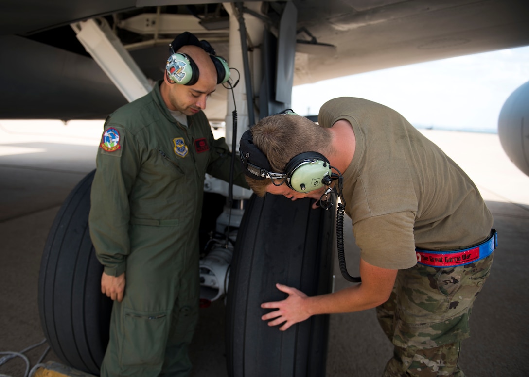 U.S. Air Force Tech. Sgt. Norbert Roland (left) and Senior Airman Zachery Murray (right), 92nd Aircraft Maintenance Squadron flying crew chiefs, examine landing gear during pre-flight checks on a KC-135 Stratotanker at Dyess Air Force Base, Texas, Aug. 13, 2019.