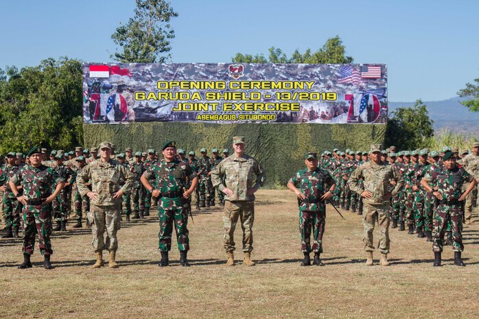 The 2019 Garuda Shield leaders from both armies pose for a picture with a formation of U.S. and Indonesian forces during the 2019 Garuda Shield opening ceremony Aug. 19, 2019, at Dodiklatpur, Indonesia. Garuda Shield is an annual, bilateral military partnership sponsored by the U.S. Army Pacific and hosted annually by Tentara Nasional Indonesia. (U.S. Army photo by Pfc. Ezra Camarena, 28th Public Affairs Detachment)