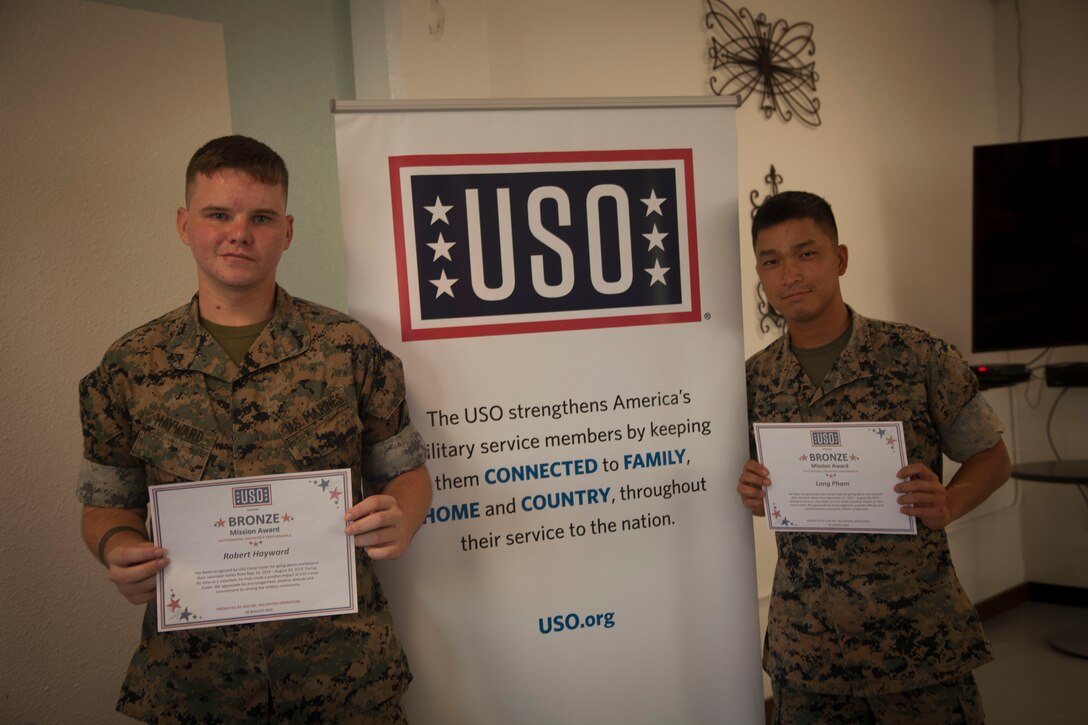 U.S. Marine Corps Lance Cpl. Robert Hayward (left), and Cpl. Lang Pham (right), 3rd Transportation Support Battalion, Combat Logistics Regiment 3, 3rd Marine Logistic Group, III Marine Expeditionary Force, are awarded the Bronze Mission award accolade at the United Service Organization Volunteer Recognition at Camp Foster, Okinawa, Japan Aug. 20, 2019.
