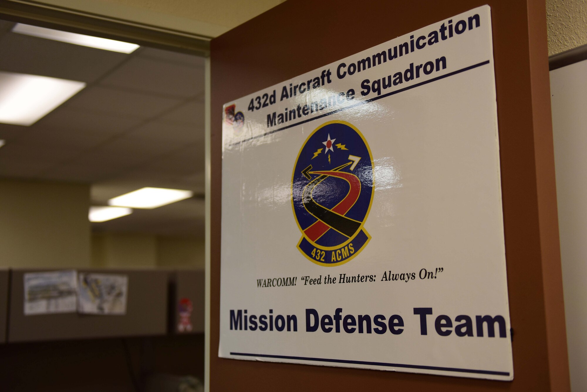 A Mission Defense Team sign hangs inside the 432nd Aircraft Communications Maintenance Squadron building at Creech Air Force Base, Nevada, April 29, 2019. MDTs are the result of the Cyber Squadron Initiative (CS-I), which is a plan to move communications squadrons away from Information Technology (IT) service and toward a mission set that involves the cyberspace side of their wing’s operational mission. (U.S. Air Force photo by Airman 1st Class Haley Stevens)