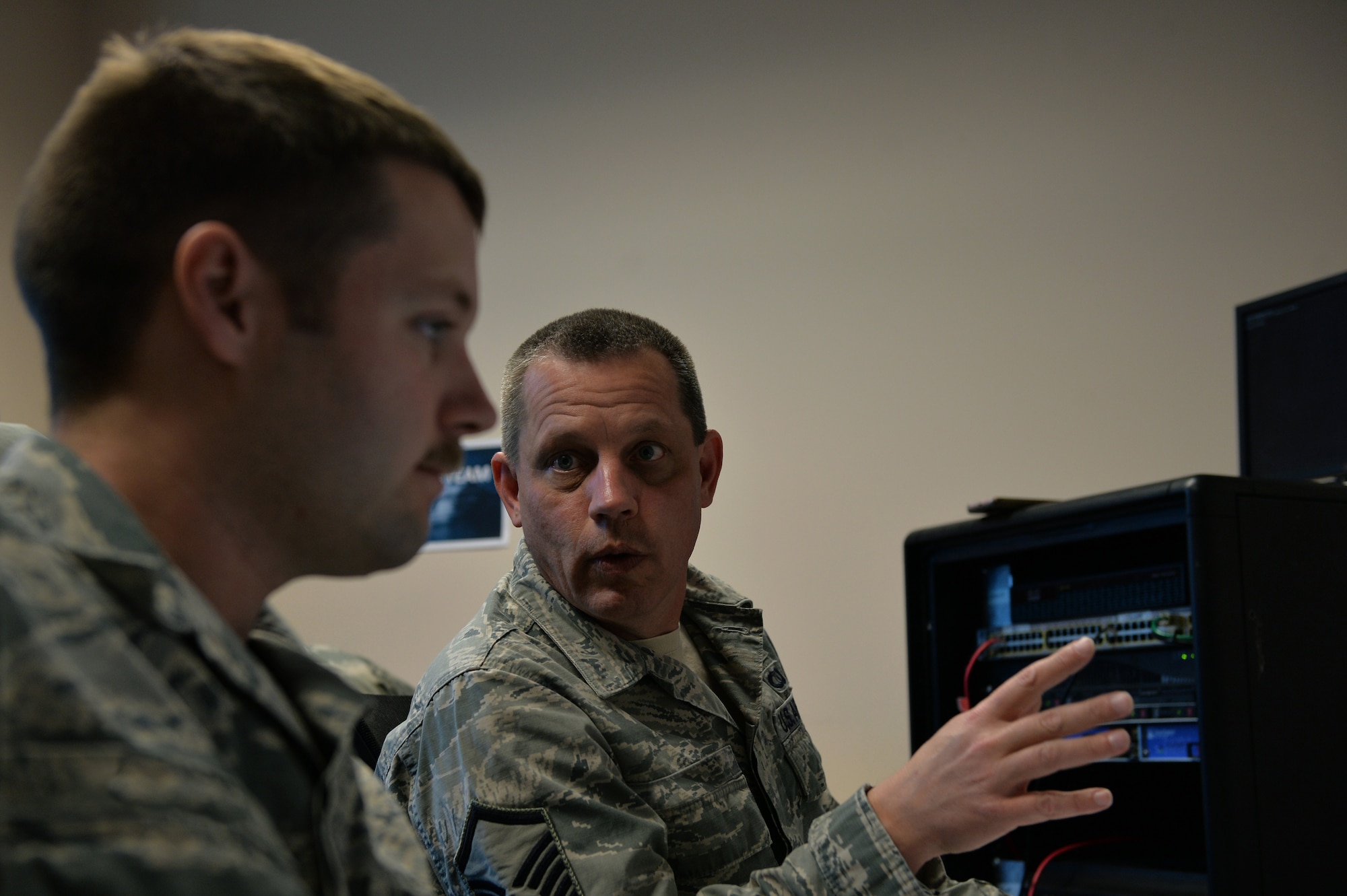 Members of the Mission Defense Team at the 432nd Aircraft Communications Maintenance Squadron discuss a simulated cyber-attack during a cyber-defense training exercise at Creech Air Force Base, Nevada, Dec. 21, 2017. The Air Combat Command selected the 432nd ACMS to test the possibilities of the Cyber Squadron Initiative (CS-I) by defending the Remotely Piloted Aircraft network. (U.S. Air Force photo by Airman 1st Class Haley Stevens)