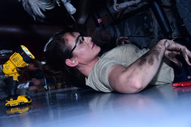 A photo of an airman working under a fire truck