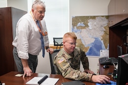 Richard Parker, senior operations supervisor, 1st Theater Sustainment Command (TSC), reviews a document with Maj. John Dunlapp, chief of future operations, 1st TSC, Aug. 19, 2019 at Fort Knox, Ky.