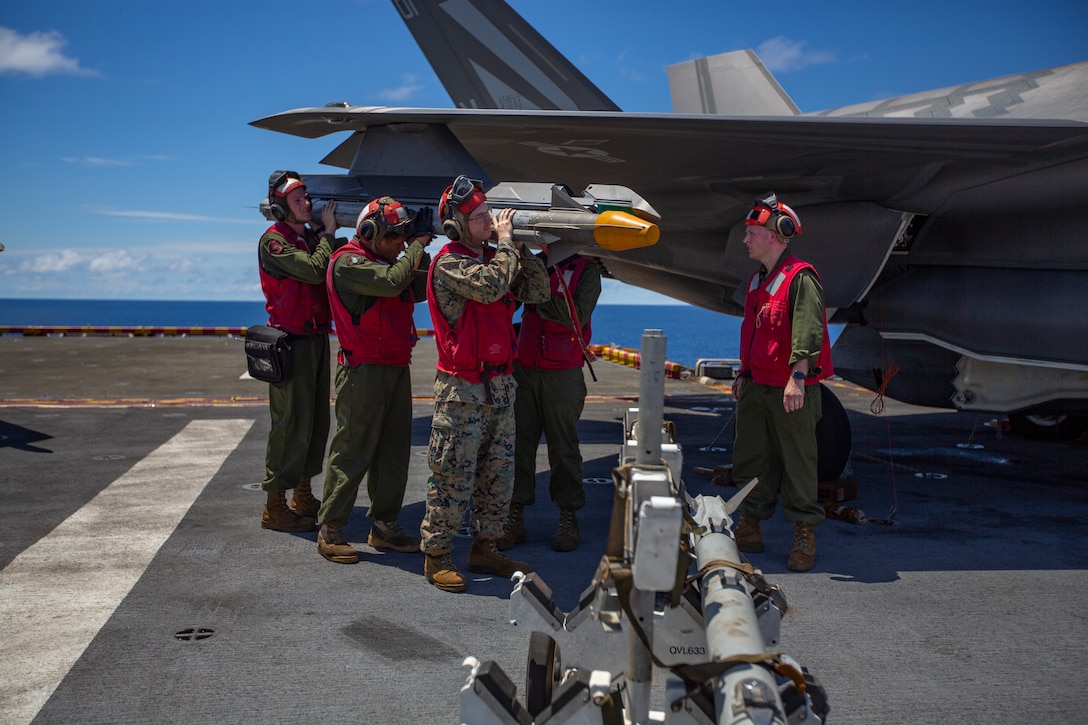 Ordnance Marines with Marine Medium Tiltrotor Squadron 265, 31st Marine Expeditionary Unit, load an AIM- 9X Sidewinder missile onto an F-35B Lightning II fighter aircraft prior to a defensive combat air patrol rehearsal aboard the amphibious assault ship USS Wasp, Pacific Ocean, August 7, 2019. Wasp, flagship of the Wasp Amphibious Ready Group, with embarked 31st MEU, is operating in the Indo-Pacific region to enhance interoperability with partners and serve as ready-response force for any type of contingency, while simultaneously providing a flexible and lethal crisis response force ready to perform a wide range of military operations.