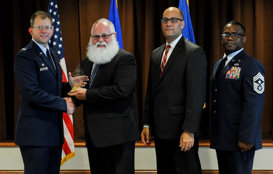 John Romines, retired National Air and Space Intelligence Center employee, accepts the NASIC Wall of Honor award from Col. Parker H. Wright, NASIC commander, Aug. 2 at the Wright-Patterson Club at Wright-Patterson Air Force Base, Ohio. The Wall of Honor award is given to select NASIC alumni in recognition of their lasting contributions and significant achievements.