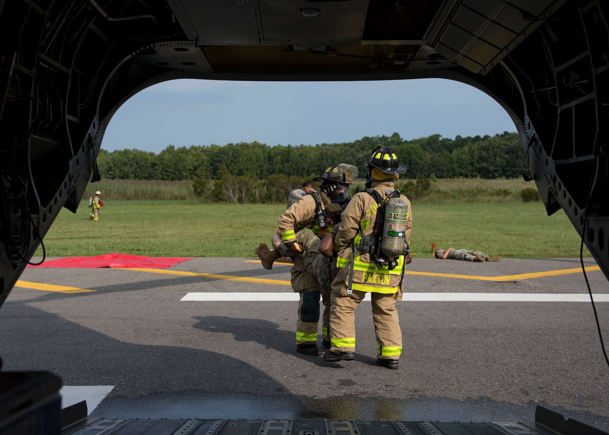 Members assigned to the 733d Civil Engineer Division evacuate a patient during an aircraft crash exercise at Joint Base Langley-Eustis, Virginia, Aug. 13, 2019.