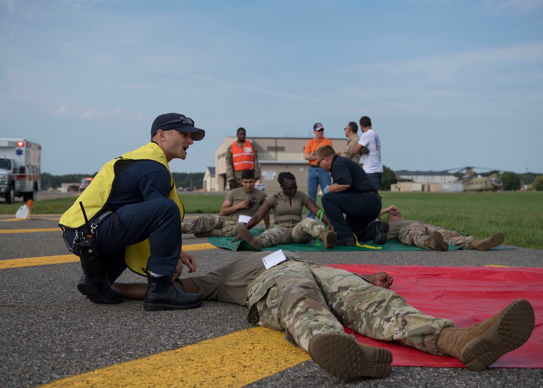 Members assigned to the 733d Civil Engineer Division assess patient injuries during an aircraft crash exercise at Joint Base Langley-Eustis, Virginia, Aug. 13, 2019.