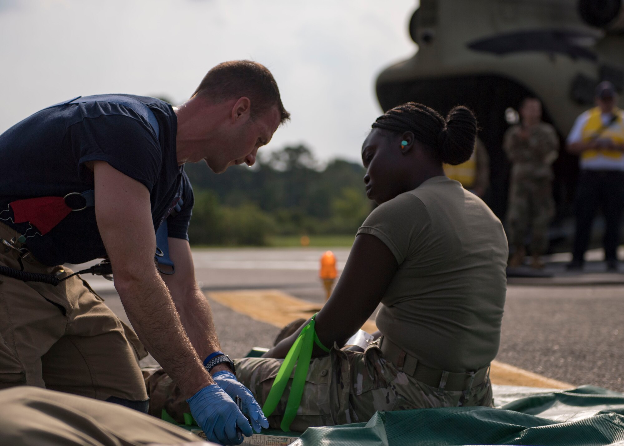 Brian Yohn, 733d Civil Engineer Division firefighter, checks a patient’s status during an aircraft crash exercise at Joint Base Langley-Eustis, Virginia, Aug. 13, 2019.
