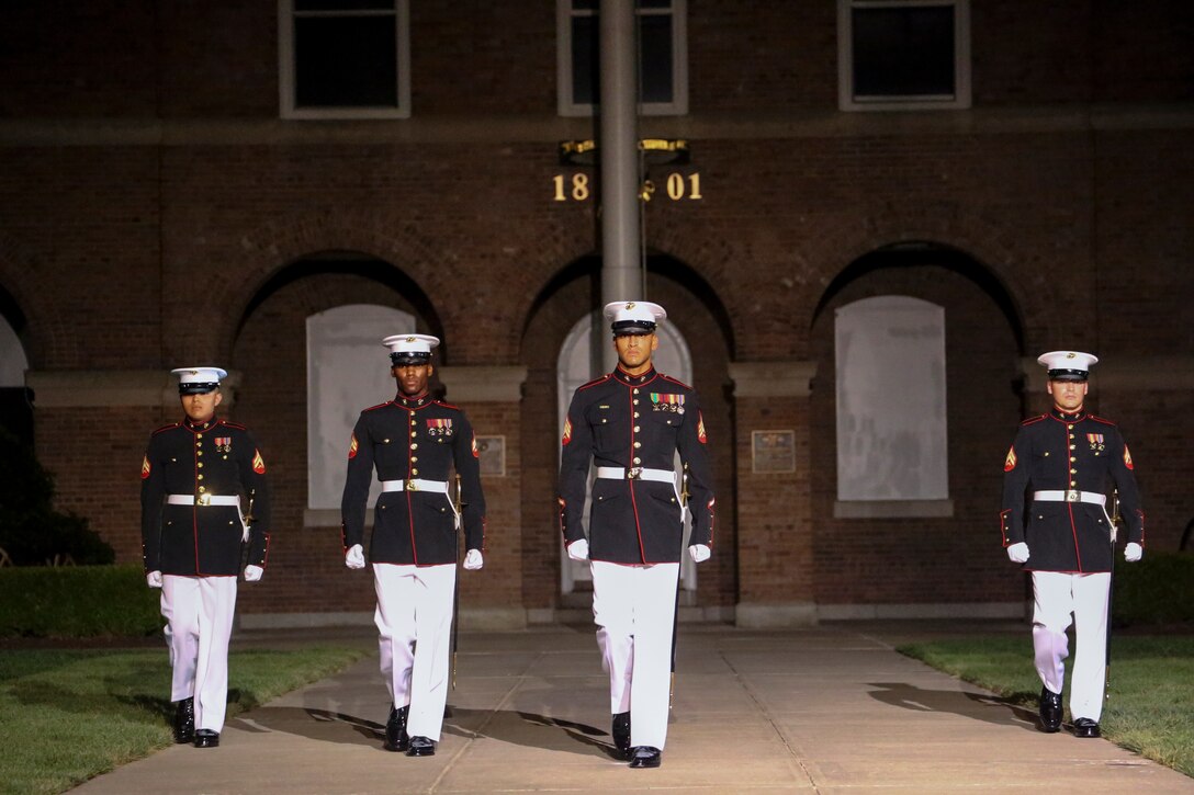 Marines with the noncommissioned officer parade marching staff, Marine Barracks Washington, D.C., march down Center Walk during the Noncommissioned Officer Friday Evening Parade at Marine Barracks Washington, D.C., Aug. 16, 2019. The hosting official for the evening was Lt. Gen. John J. Broadmeadow, director of Marine Corps Staff and the Under Secretary of the Navy, the Honorable Mr. Thomas B. Modly, was the guest of honor. (U.S. Marine Corps photo by Sgt. Robert Knapp/Released)