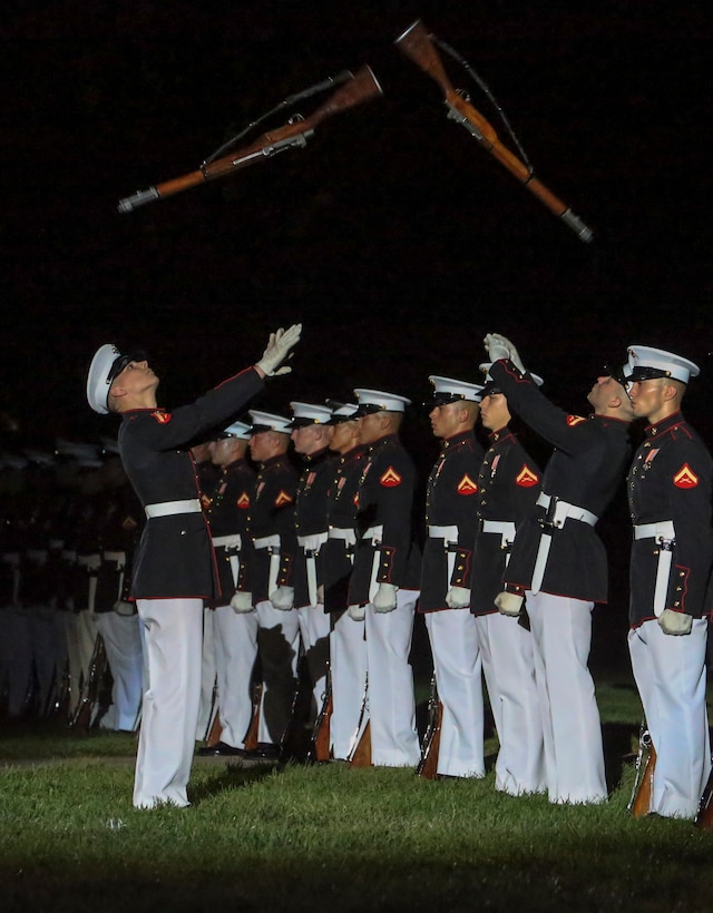 Marines with the noncommissioned officer parade marching staff, Marine Barracks Washington, D.C., march across Center Walk during the Noncommissioned Officer Friday Evening Parade at Marine Barracks Washington, D.C., Aug. 16, 2019. The hosting official for the evening was Lt. Gen. John J. Broadmeadow, director of Marine Corps Staff and the Under Secretary of the Navy, the Honorable Mr. Thomas B. Modly, was the guest of honor. (U.S. Marine Corps photo by Sgt. Robert Knapp/Released)