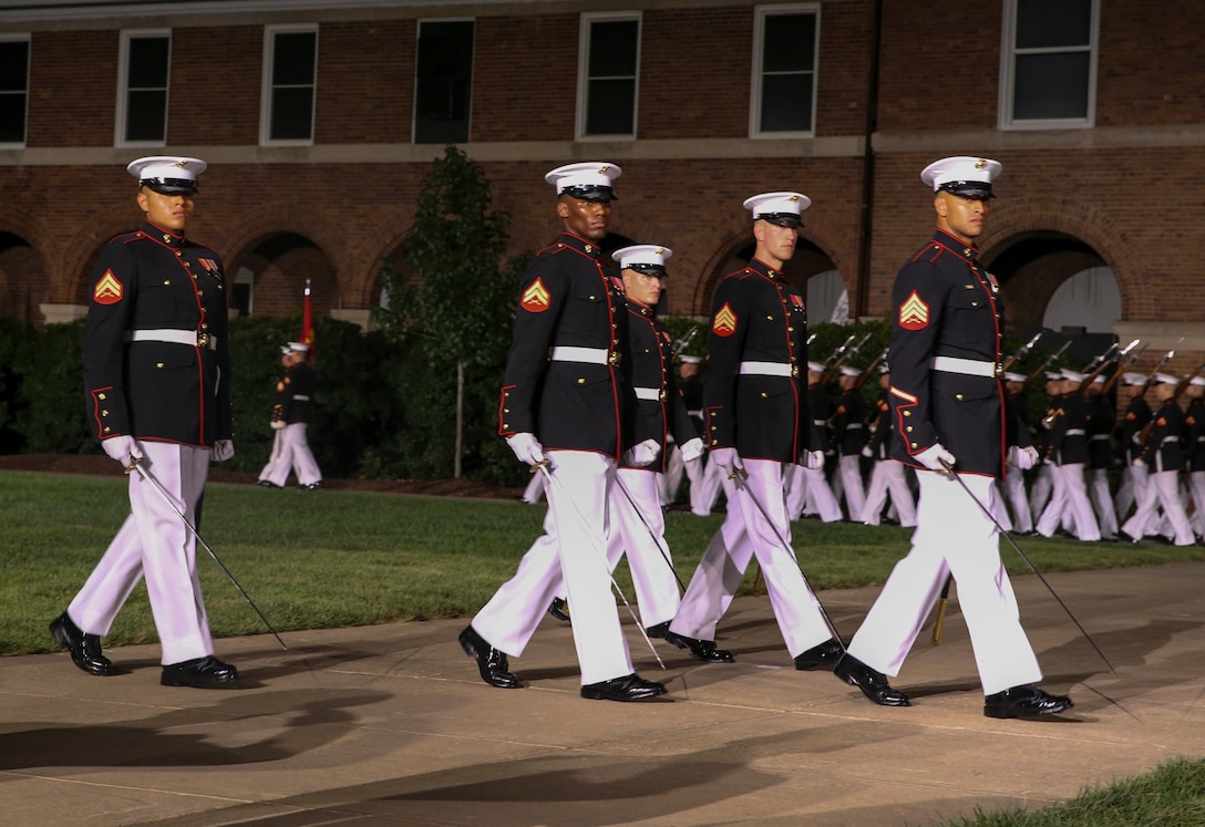 Marines with the noncommissioned officer parade marching staff, Marine Barracks Washington, D.C., march across Center Walk during the Noncommissioned Officer Friday Evening Parade at Marine Barracks Washington, D.C., Aug. 16, 2019. The hosting official for the evening was Lt. Gen. John J. Broadmeadow, director of Marine Corps Staff and the Under Secretary of the Navy, the Honorable Mr. Thomas B. Modly, was the guest of honor. (U.S. Marine Corps photo by Sgt. Robert Knapp/Released)