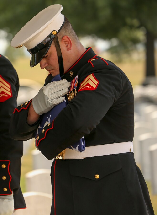 Corporal Luke Givens, Body Bearer, Bravo Company, Marine Barracks Washington, D.C., holds the flag that covered Maj. Gen. Ronald L. Beckwith’s casket during his full honors funeral at Arlington National Cemetery, Arlington, Virginia, Aug. 7, 2019. Beckwith commissioned as a second lieutenant in the Marine Corps in 1957 and served several combat tours in Vietnam as a combat aviator. Beckwith retired from the Marine Corps in 1991 after 34 years of service and passed away on Feb. 19, 2019. (U.S. Marine Corps photo by Pfc Allen Sanders)