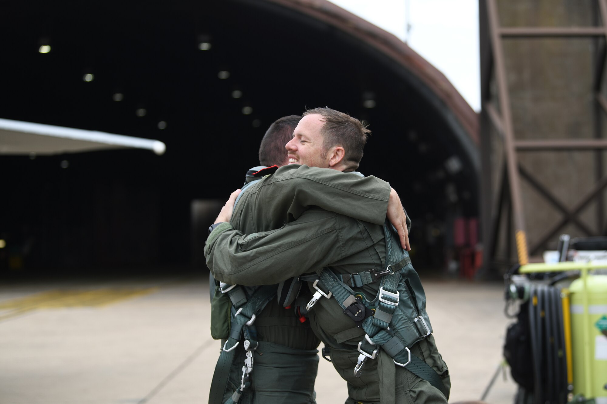 U.S. Air Force Staff Sgt. Derreck Day, 48th Operations Support Squadron Survival, Evasion, Resistance and Escape specialist hugs, U.S. Air Force Capt. Caleb Wyatt, 493rd Fighter Squadron F-15C Eagle electronic combat pilot, after a familiarization orientation flight at Royal Air Force Lakenheath, England, Aug. 16, 2019. Due to the nature of military service, this is the first duty station the pair have shared at the same time since beginning their Air Force journey. (U. S. Air Force photo by Airman 1st Class Shanice Williams-Jones)