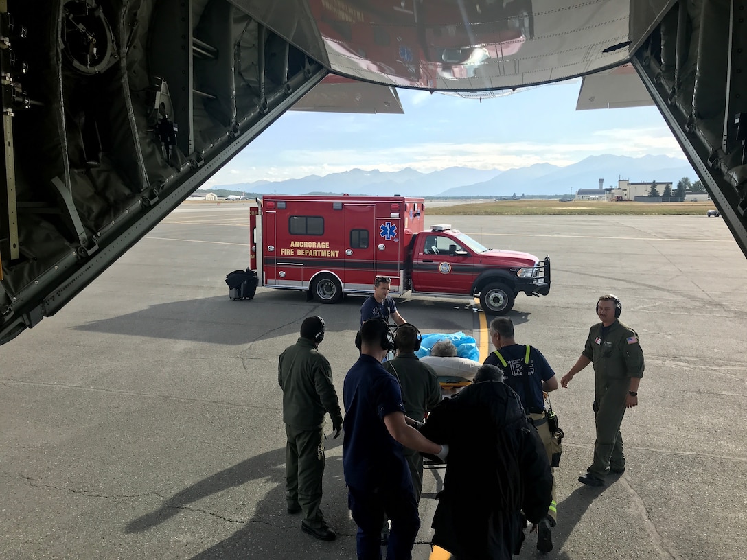 Coast Guard Air Station Kodiak HC-130J Hercules aircrew helps to complete a long-range medical evacuation of two people to Anchorage on Aug. 3, 2019.