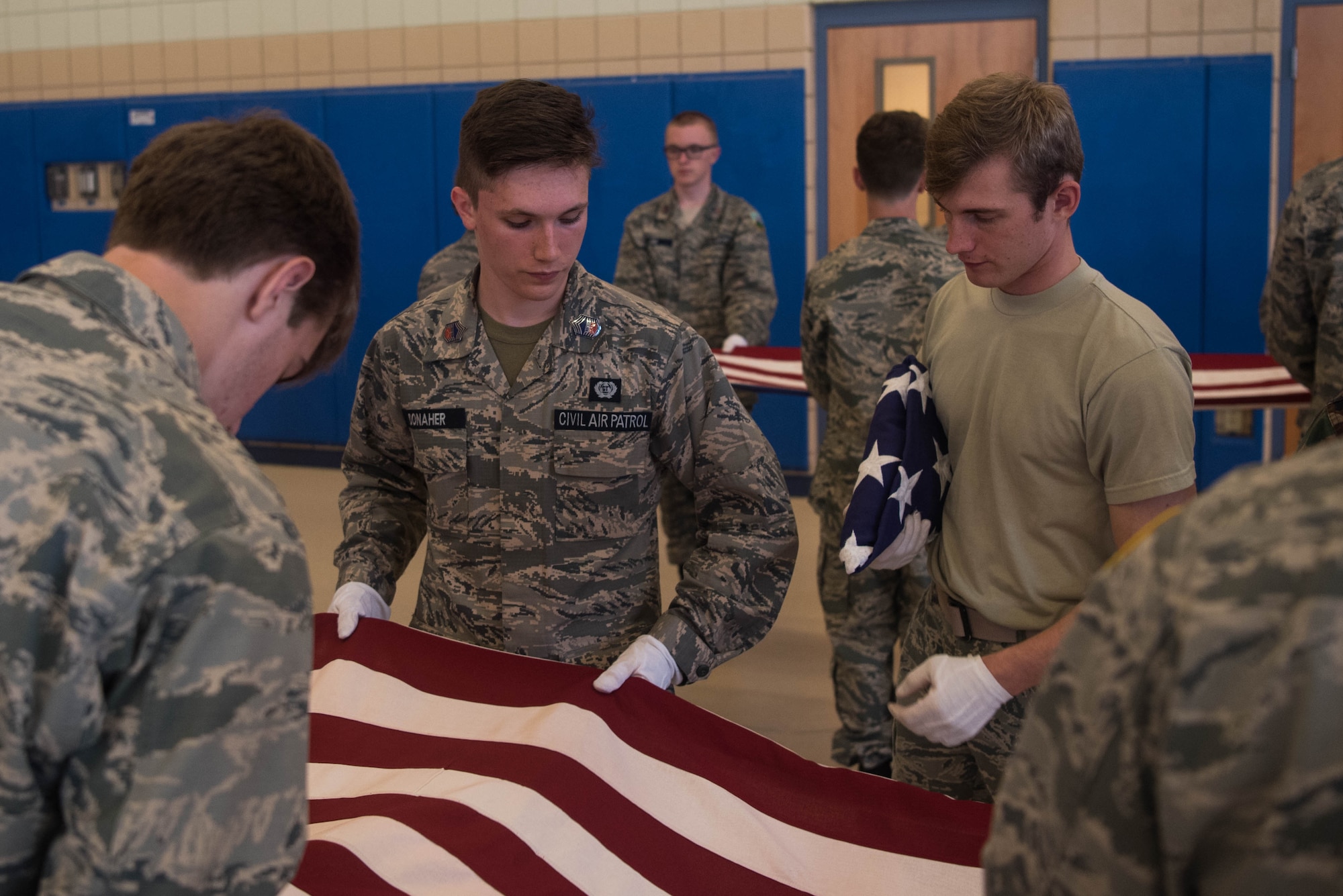 A member of the Langley Honor Guard educates members of the Civil Air Patrol on how to properly fold the U.S. flag at Joint Base Langley-Eustis, Virginia, July 17, 2019. JBLE hosting the Mid Atlantic Honor Guard Academy allowed cadets from every region in CAP to work with official United States Air Force Honor Guard members. (U.S. Air Force photo by Airman 1st Class Marcus M. Bullock)