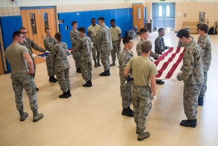 Members of the Langley Honor Guard educate members of the Civil Air Patrol on how to properly fold the U.S. Flag at Joint Base Langley-Eustis, Virginia, July 17, 2019. The Puerto Rico Wing, the National-Capitol Wing and 30 other state-based wings of CAP have cadets attending the week-long Mid-Atlantic Honor Guard Academy. (U.S. Air Force photo by Airman 1st Class Marcus M. Bullock)