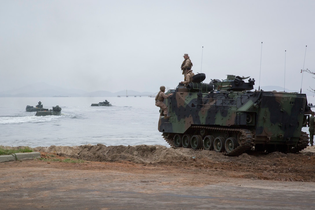 Marine amphibious assault vehicles come ashore.