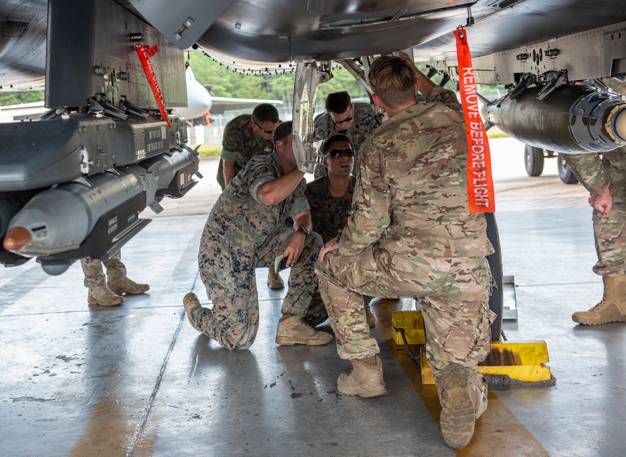 Staff Sgt. Ryan Carel, 4th Civil Engineer Squadron explosive ordnance disposal technician, shows U.S. Marine EOD technicians how to safely pin landing gear on an F-15E Strike Eagle, August 14, 2019, at Seymour Johnson Air Force Base, North Carolina. The Marines, assigned to the 8th Engineer Support Battalion, 2nd Marine Logistics Group, came to Seymour Johnson AFB to become familiar with aircraft weaponry. (U.S. Air Force photo by Senior Airman Kenneth Boyton)