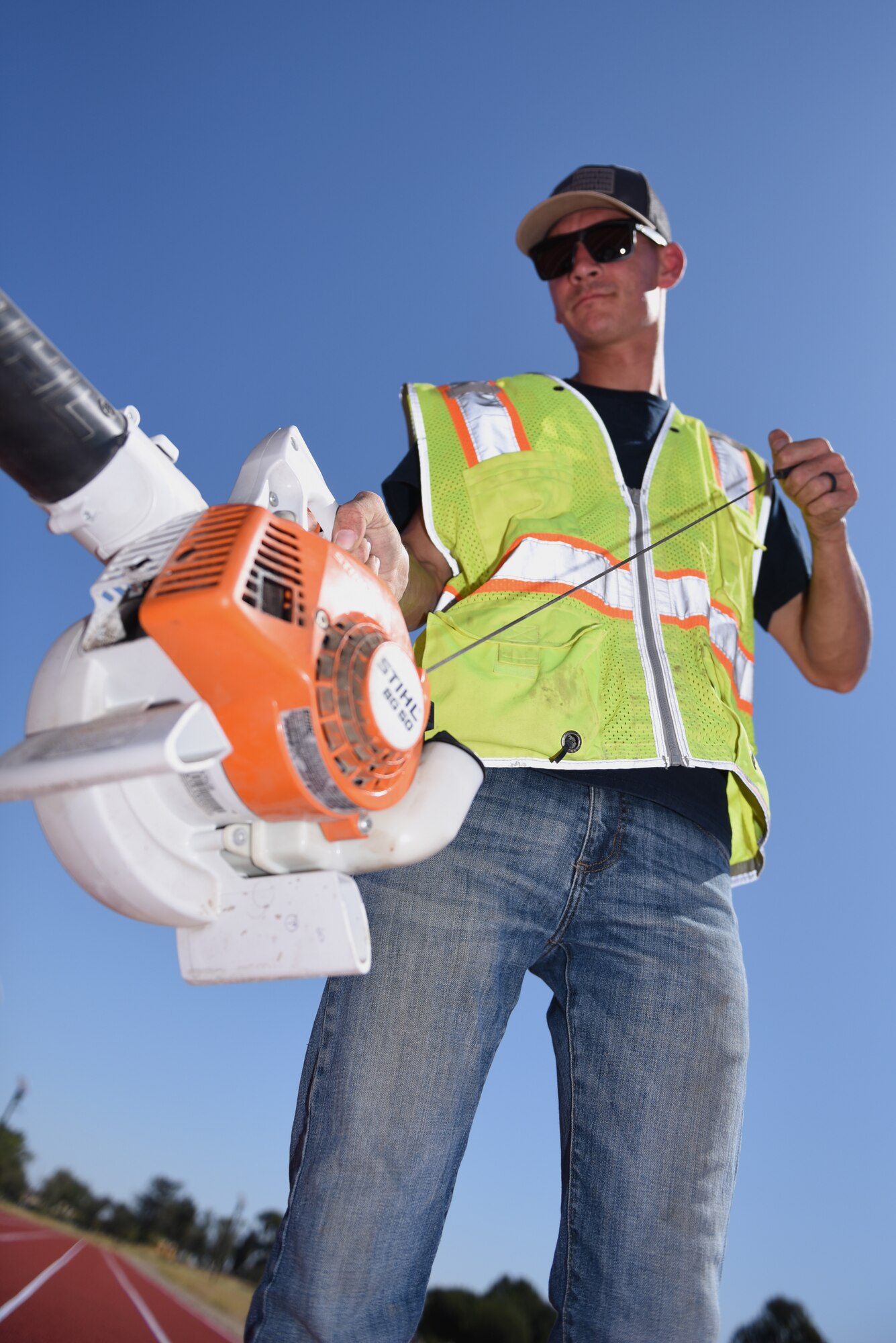 Justin Gilliland, CMA Construction services, removes debris from the Fitness Center Track prior its opening ceremony Aug. 14, 2019, at Travis Air Force Base, California. The tracks recently underwent renovations which included ripping the old track from the ground, placing a solid base of concrete and asphalt, laying down eight layers of rubber padding and painting stripes on the new lanes. (U.S. Air Force photo by Airman 1st Class Cameron Otte)