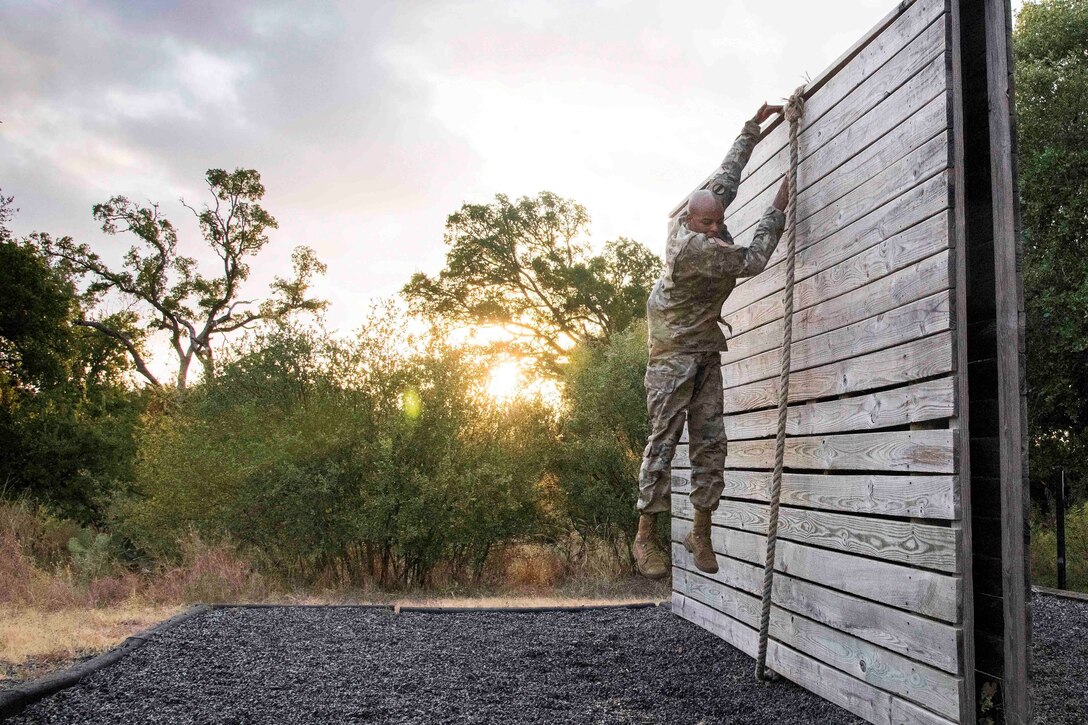 A soldier jumps down from a wall.