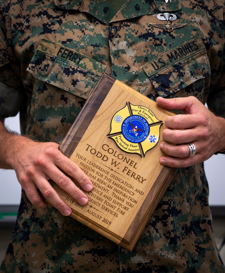 U.S. Marine Corps Col. Todd W. Ferry, former Marine Corps Air Station Cherry Point, commanding officer, holds a plaque presented to him by the Cherry Point Fire and Emergency services at the air station, Aug. 15, 2019. The plaque was presented as a token of appreciation from the unit for his hard work and dedication to the emergency services, while serving as the commanding officer.  (U.S. Marine Corps photo by Pfc. Aliannah T. Bartok)