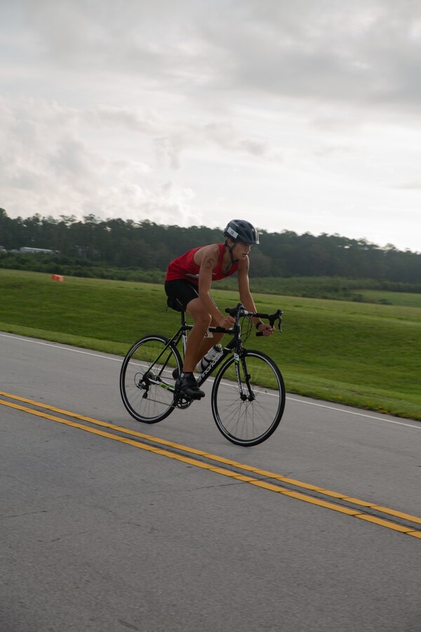 Kekoa Romero pedals through the bike ride portion of the Marine Corps Community Services’ 20th Annual Sprint Triathlon at Marine Corps Air Station Cherry Point, North Carolina, Aug. 17, 2019. Around 90 participants, including services members and their families from the local community and surrounding area, took part in a 400-meter swim, 10-mile bike ride and a three mile run. Athletes braved muggy temperatures and stiff competition in the grueling, but popular event. (U.S. Marine Corps photo by Lance Cpl. Alexandra Santos Arambulo)