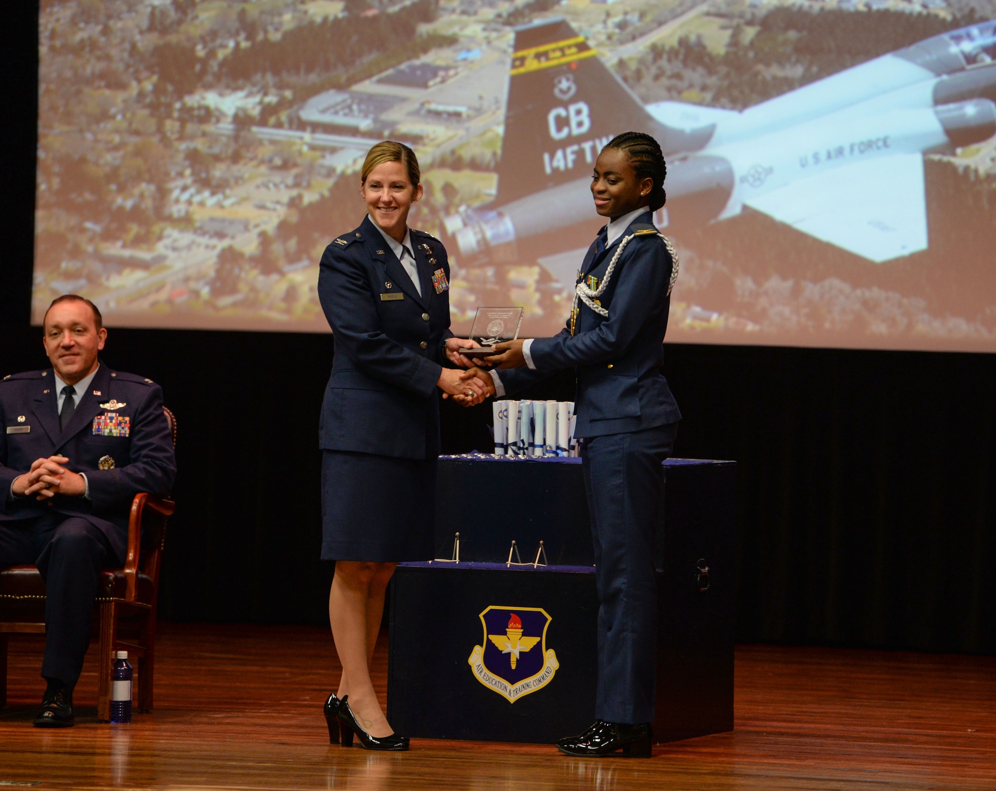 Col. Samantha Weeks, 14th Flying Training Wing commander, gives an award to 1st Lt. Sanni Kafayat, 14th Student Squadron student pilot, at the Special Undergraduate Pilot Training Class’s 19-21/22 graduation ceremony Aug. 16, 2019, at Columbus Air Force Base, Miss. Kafayat is Nigeria’s first female fighter pilot. (U.S. Air Force photo by Airman Davis Donaldson)